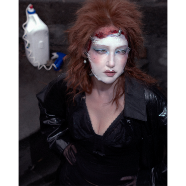 A women with spcial effects make-up, she looks like aan 80s rockstar , her face bloody mask